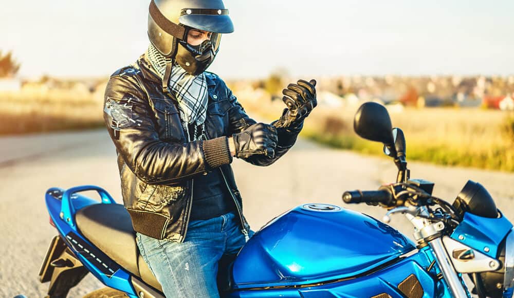 Motorcyclist wearing and fitting the safety gear.