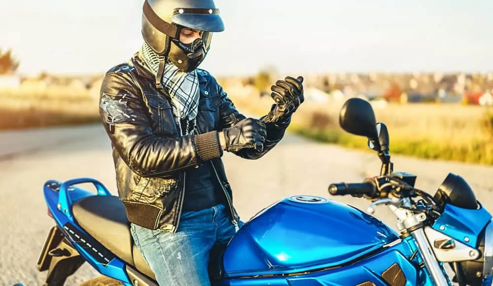 Motorcyclist wearing and fitting the safety gear.