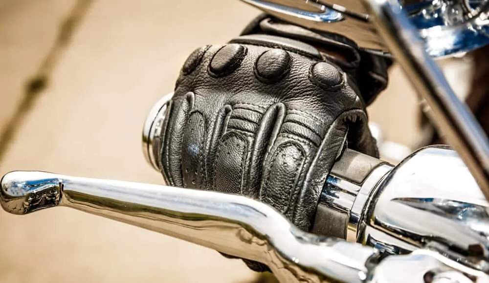 Motorcyclist wearing a thick glove to prevent hand numbness.